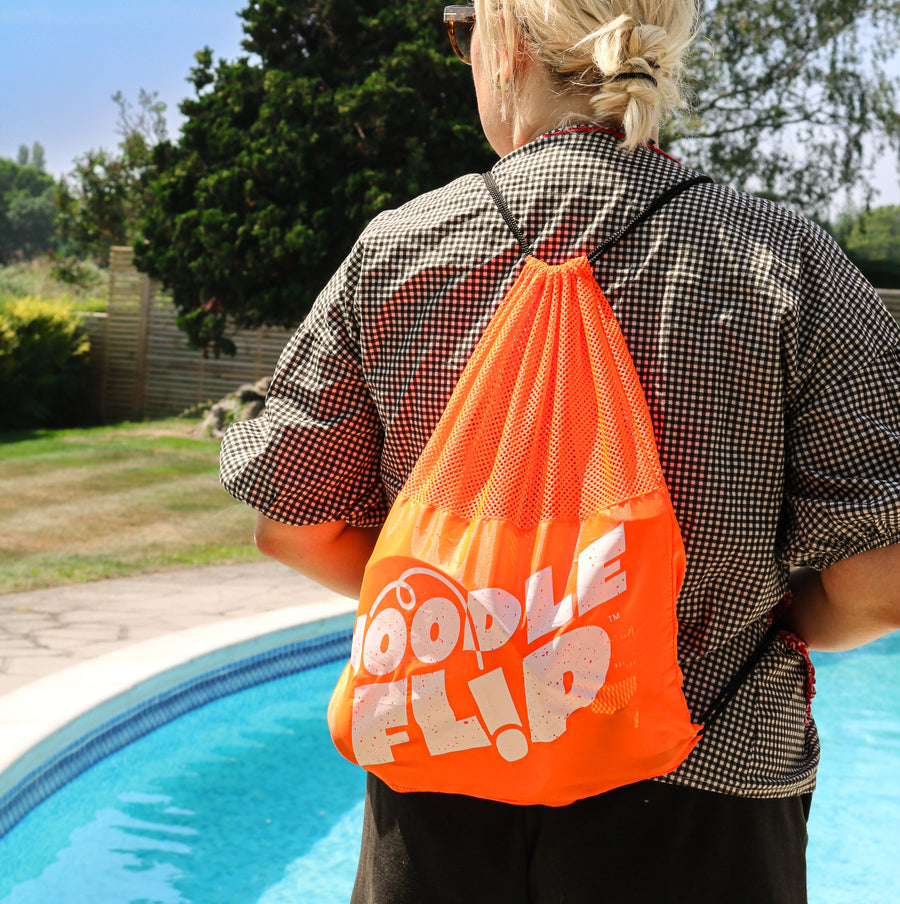 Woman with blonde hair wearing the Noodle Flip drawstring bag