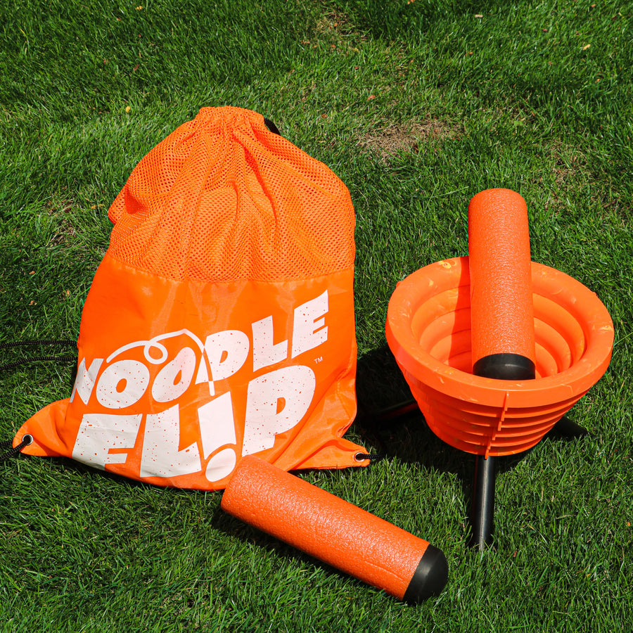 Noodle Flip Drawstring Bag on the lawn with the game in front of it