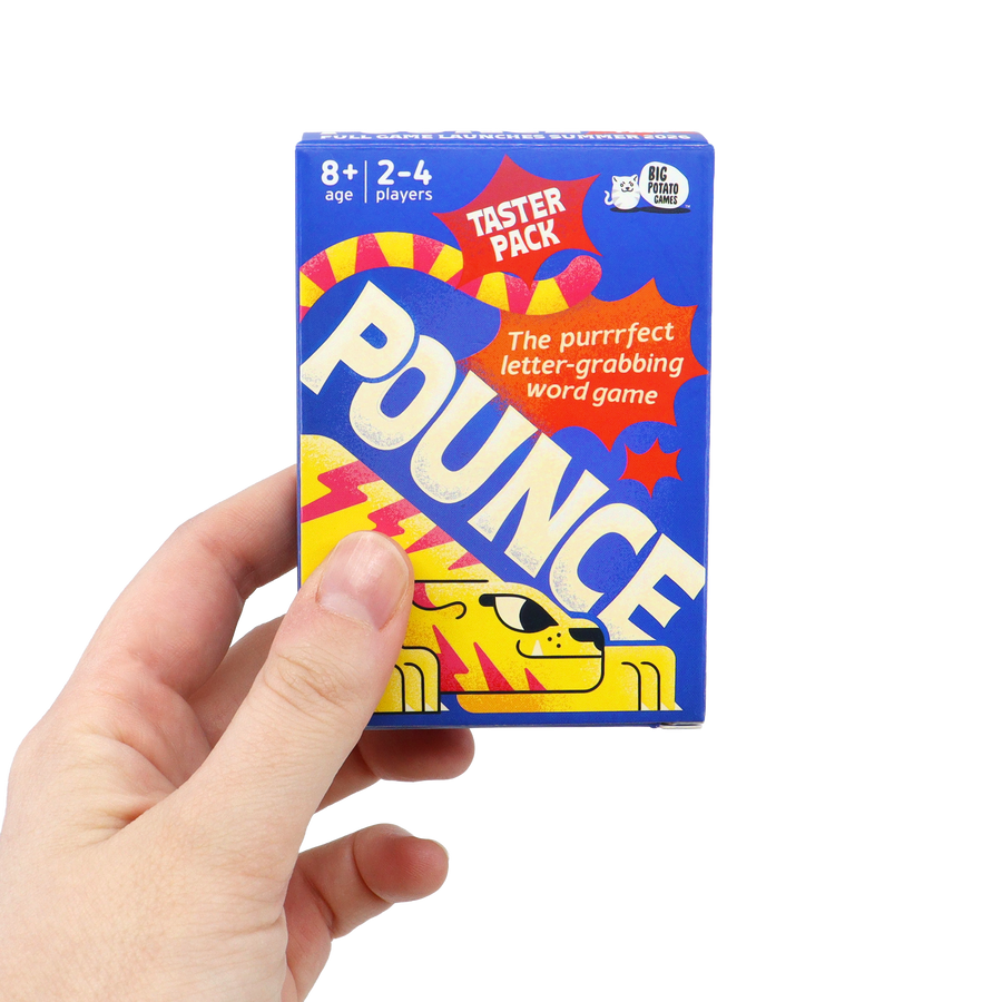 A hand holds the Pounce taster pack against a plain black background. The small blue box features a yellow cat illustration and text describing it as “the purrrfect letter-grabbing word game.”