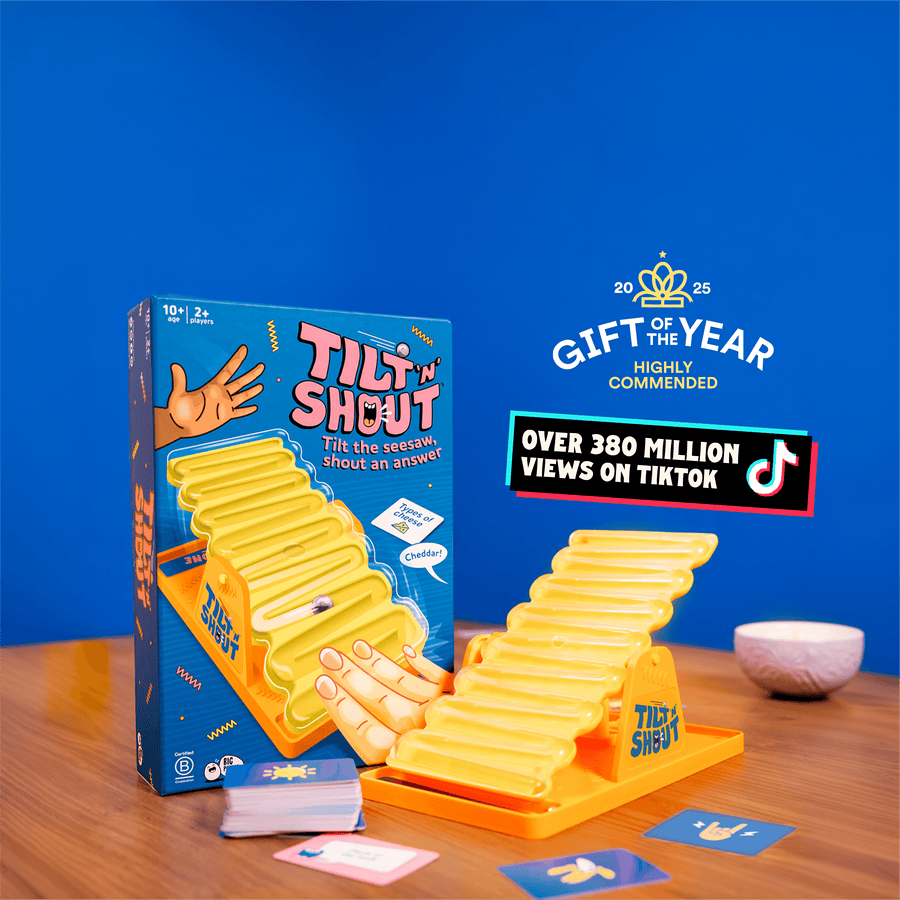 Tilt 'N Shout board game set on a wooden table against a solid blue background, with the yellow seesaw, and category cards,. Promotional text and TikTok badges appear to the right.
